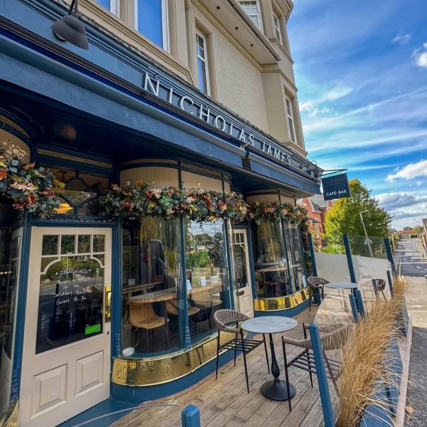 A café-bar frontage with clean glass and floral displays.