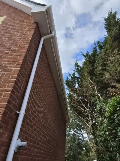 Clean white fascia and guttering against a blue sky.