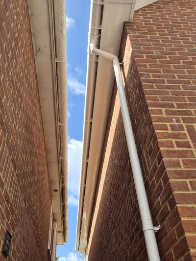 Two adjoining roofs, one gutter clean and one still dirty.