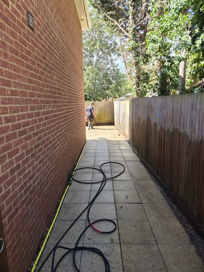 A fence part-cleaned, the washed section noticeably lighter.