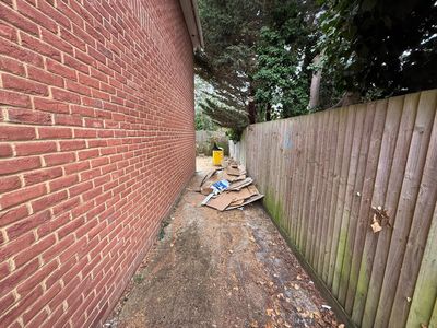 A side passage with dirt-covered slabs and a pile of cardboard.